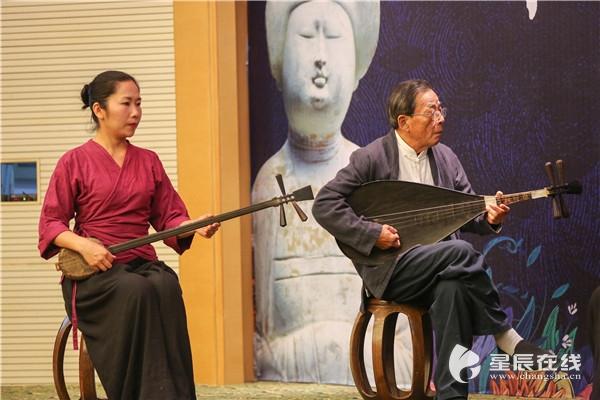 (非遗南音项目国家级传承人苏统谋[右一]用横抱曲颈琵琶进行弹奏.